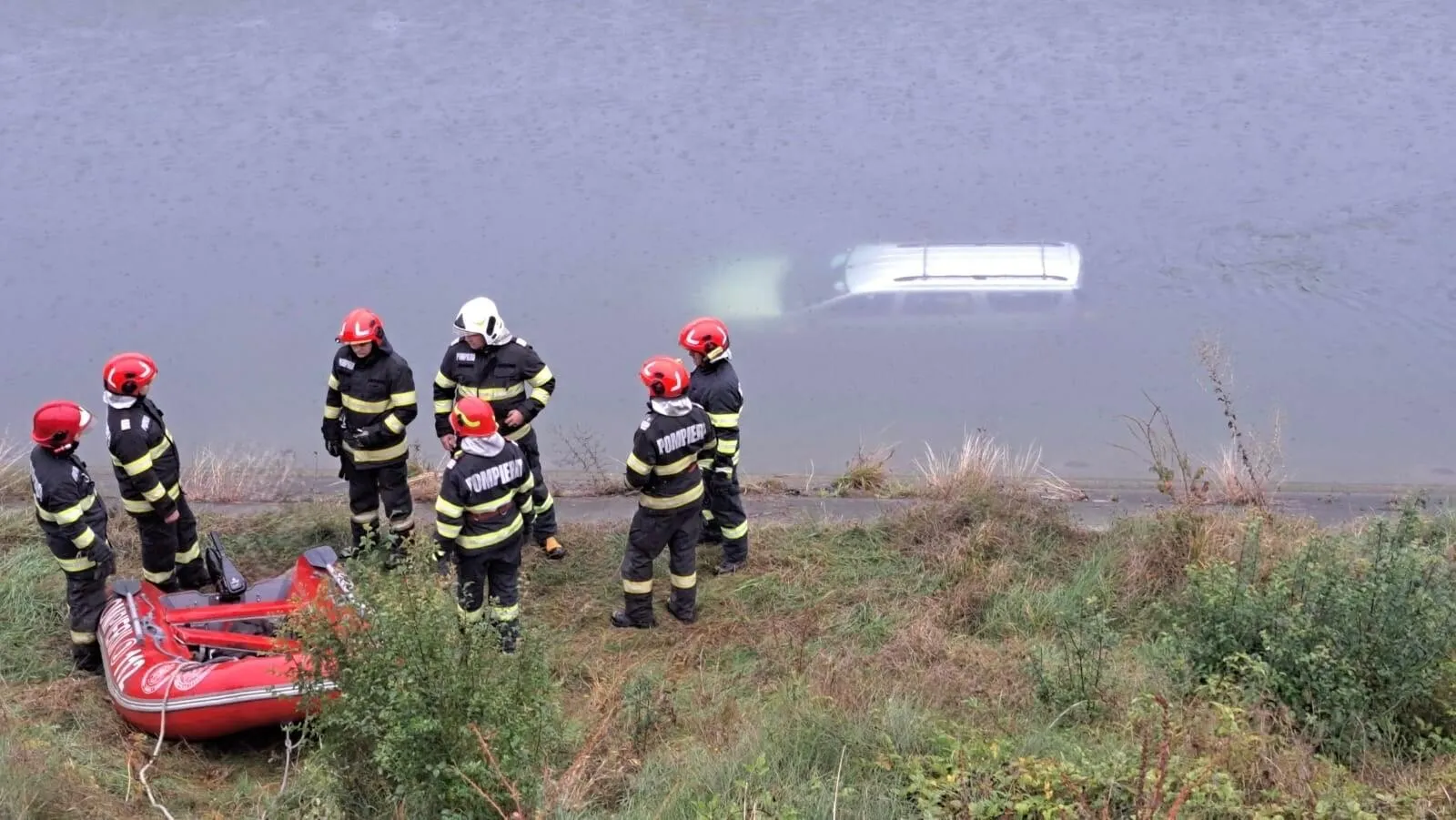 FOTO Tragedie evitată: un bărbat și un copil au supraviețuit după ce s-au urcat pe plafonul unei mașini cazute în apă