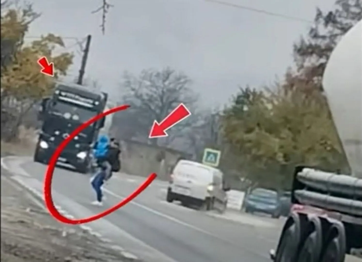 FOTO Inconștiență totală! Mamă cu copilul în brațe, surprinsă traversând printre TIR-uri. Poliția trage un semnal de alarmă