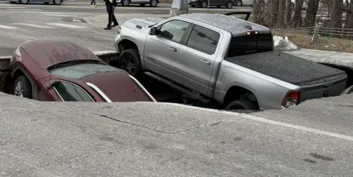 VIDEO Momentul în care un crater uriaș devorează două mașini în plină intersecție. Imaginile au fost surprinse de camere